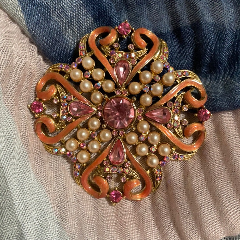 Express brooch with pink with iridescent stones and pearls.